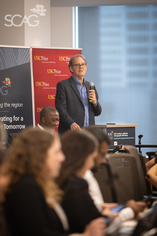 Man speaking at podium during a conference.